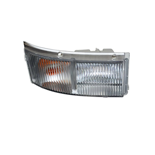 A replacement car headlight assembly with a clear ribbed lens, silver metal housing, and an orange reflector visible on the left side, isolated on a white background.  Isuzu F Series Front Bumper Bar Flasher R-H – Under HeadLamp